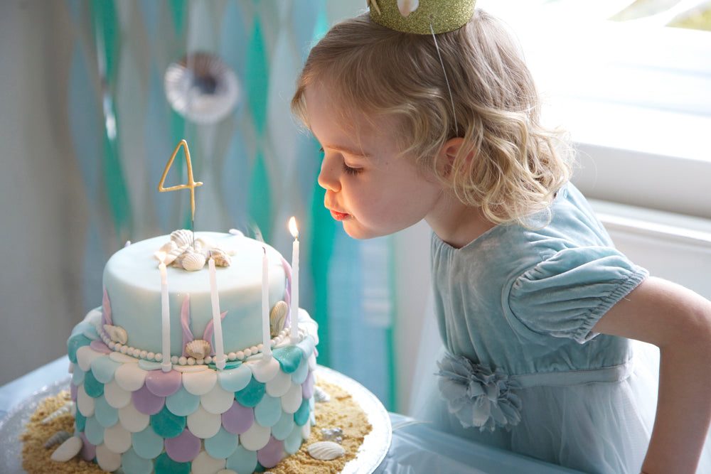 mermaid cake blowing out candles