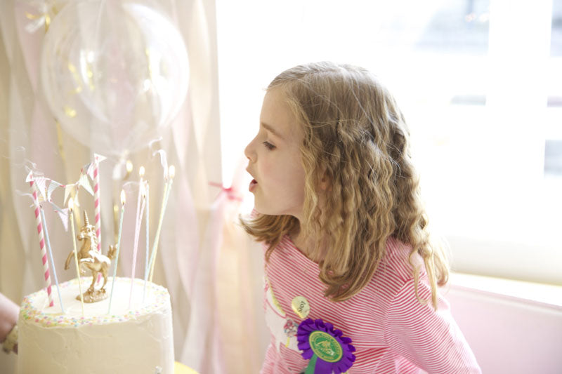 unicorn cake blowing out candles